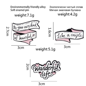 Three enamel ribbon pins with quotes including Be your own kind of beautiful and Wanderful life