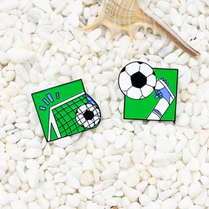 Cartoon soccer enamel pins featuring a dynamic goal scene and football cleats on pebbles