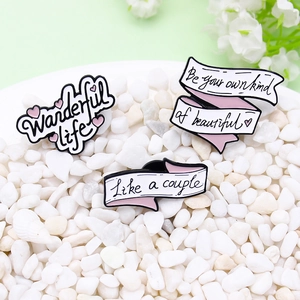 Three-piece black and white enamel pin set with ribbon designs and heart elements