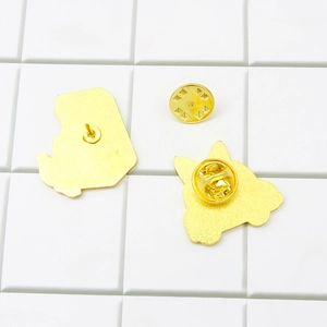 Dos de broches d'animaux en métal doré avec fermoirs papillon sur carreaux blancs