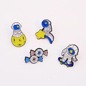 Enamel astronaut and eyeball candy lapel pins set on white background