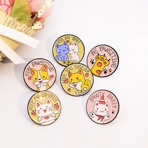 Cartoon enamel pins featuring cute cats and dogs with paw prints on a white background