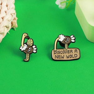 Détail de broches en émail autruche avec slogans Discover a New World et Newly Born