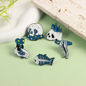 Five-piece set of celestial skull enamel pins with starry galaxy designs on a green background