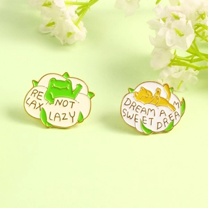 Cartoon frog and cat enamel pins with Relax Not Lazy and Sweet Dream slogans