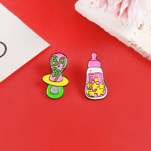 Detailansicht eines rosa Babyflaschen und Schnuller Emaille Pin Sets auf Rot