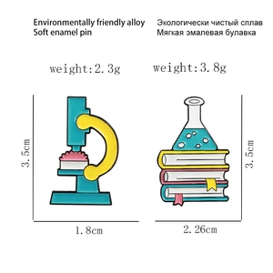 Detail view of microscope and science books enamel pins with exact size measurements