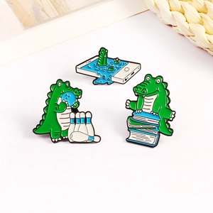 Three-piece cute green crocodile enamel pin set featuring bowling and reading designs
