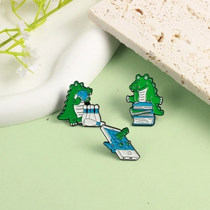Set of 3 cartoon crocodile enamel pins featuring bowling, reading and gaming themes