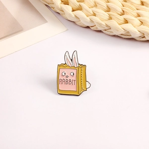 Close-up of cute cartoon rabbit enamel brooch in yellow shopping bag with RABBIT text