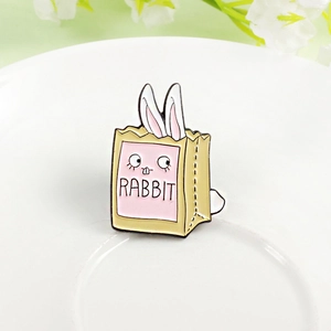 Detailed macro view of an enamel rabbit brooch tucked inside a yellow shopping bag design