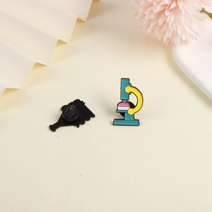 Detailed view of microscopic enamel pin with blue base and yellow frame on beige background