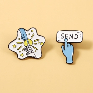 Detailed enamel pins featuring astronaut fingers touching and a blue send button