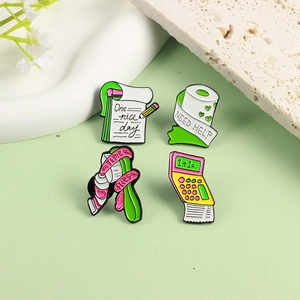 Creative enamel pin set featuring calculator, notebook and toilet paper on green desk