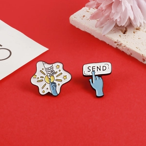 Macro shot of astronaut and alien finger touch enamel pins with creative SEND button
