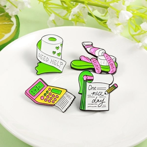 Set of four fun enamel pins featuring a calculator, notepad, tissue, and toothpaste designs