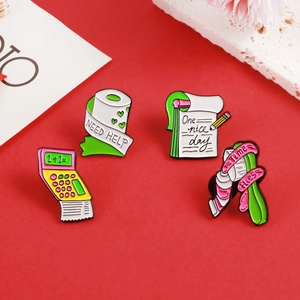 Detailed view of four creative enamel pins with calculator and notepad on red background