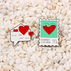 Detail of enamel lapel pins with heart envelope and energy stamp on white stones
