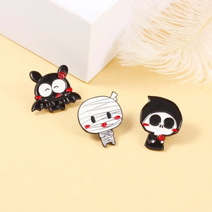 Three Halloween enamel pins featuring a bat, mummy, and reaper on a stylized display