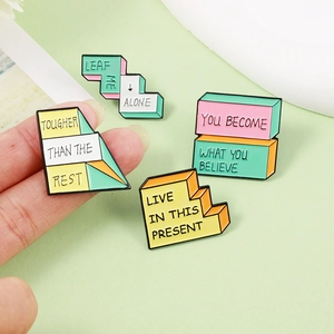 Set of pastel enamel lapel pins with inspirational slogans on a light green background