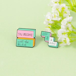 Detail of enamel lapel pins with inspirational text on a soft green background