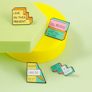 Macro shot of colorful geometric enamel pins featuring motivational quotes on vibrant stands