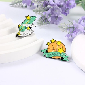 Détail de pin's en émail créatifs avec des motifs de basket-ball et de plume d'écriture