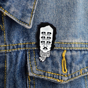 Broche en émail Edgar Allan Poe au design surréaliste sur veste en jean bleue