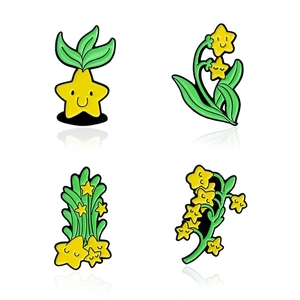 Lot de quatre pin's émaillés en forme d'étoiles souriantes avec des feuilles vertes