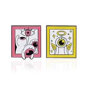 Cartoon enamel brooch set featuring pink surrealist eyes and yellow winged angel eye design