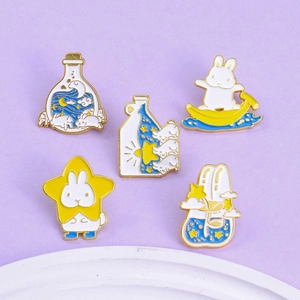 Lot de 5 broches en émail représentant des lapins blancs, étoiles et bouteille à vœux