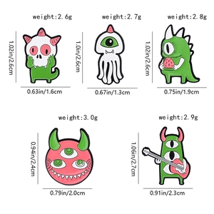 Detailed view of enamel monster pins with precise size measurements in inches and cm