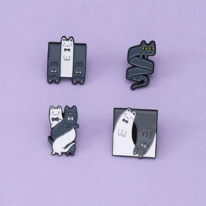 Set of four minimalist yoga cat enamel pins in creative black and grey twist designs