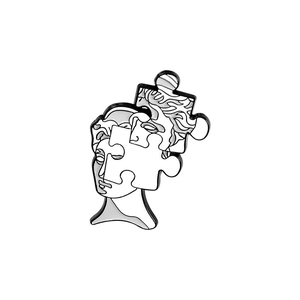 Makroaufnahme der Emaille-Gesicht-Skulptur-Brosche mit künstlerischem Puzzle-Design