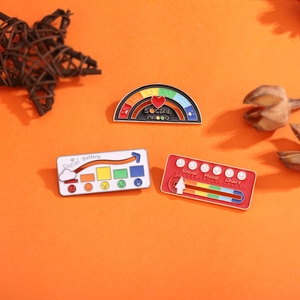 Three-piece set of social battery enamel pins on an orange background with butterfly clasp
