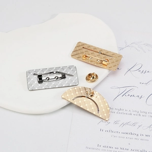Detail view of gold and silver adjustable metal brooch backs with secure safety pins
