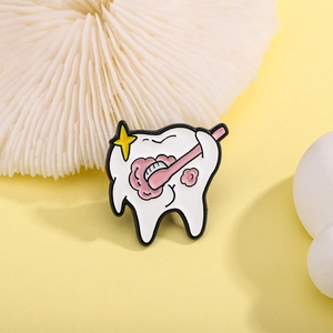 Cartoon white tooth enamel brooch pin with pink toothbrush and yellow sparkle detail