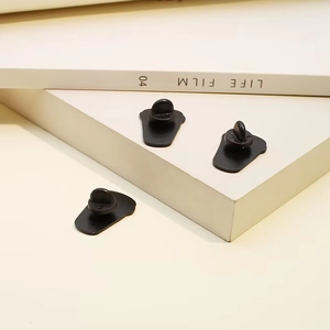 Three matte black butterfly clutch pin backs for enamel badges on a clean white background