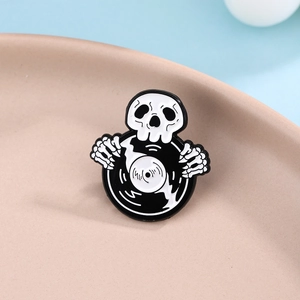 Punk style skeleton hand holding vinyl record enamel pin with black and white finish