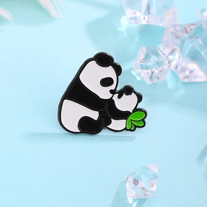 Spilla in smalto con mamma e cucciolo di panda e foglia verde su sfondo blu chiaro