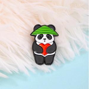 Simpatica spilla a forma di panda con cappello verde e cuore rosso in macro