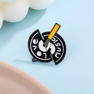Close-up of a broken vinyl record enamel pin with Love Music text on blue background