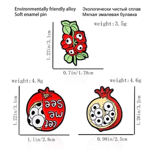 Creative pomegranate and flower enamel pins with surreal eye motif in red and green