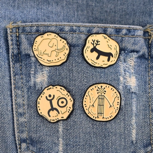 Artistic prehistoric cave painting enamel pins set with mammoth and deer on denim pocket