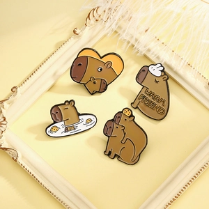 Set of four cute capybara enamel pins with various artistic poses on a vintage frame