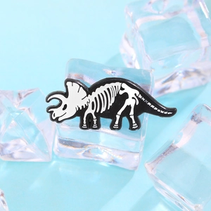 Creative triceratops skeleton enamel pin with black and white bone design on ice