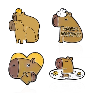 Set of four cute capybara enamel pins featuring warm friend text and orange details