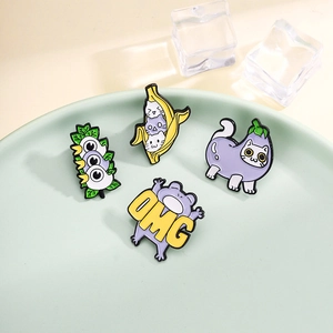 Whimsical enamel brooch set featuring banana cat, eggplant cat, and OMG frog designs