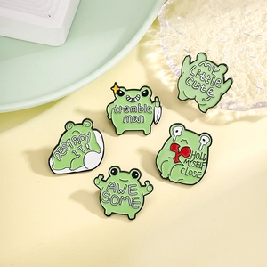 Set of five cute green frog enamel pins with various emotional expressions and creative designs
