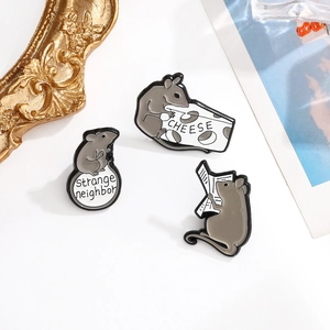 Three cute gray mouse enamel pins featuring cheese, newspaper and sphere designs